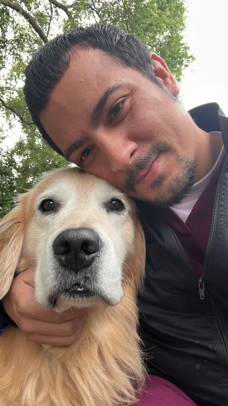 Xavier Centeno, pet sitter in Davie FL, cheek to cheek with a senior golden retriever
